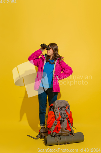 Image of Full length portrait of a cheerful young caucasian tourist girl isolated on yellow background