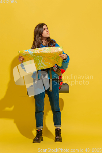 Image of Full length portrait of a cheerful young caucasian tourist girl isolated on yellow background