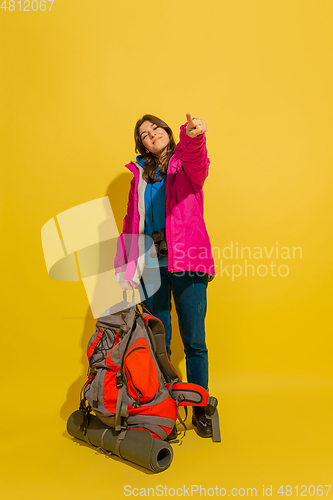 Image of Full length portrait of a cheerful young caucasian tourist girl isolated on yellow background