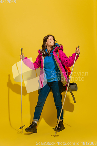 Image of Full length portrait of a cheerful young caucasian tourist girl isolated on yellow background