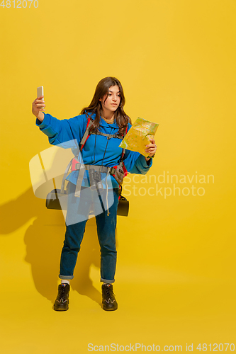 Image of Full length portrait of a cheerful young caucasian tourist girl isolated on yellow background