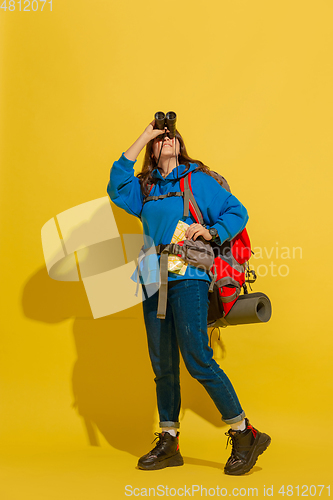 Image of Full length portrait of a cheerful young caucasian tourist girl isolated on yellow background