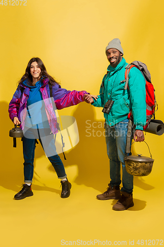 Image of Portrait of a cheerful young tourist couple isolated on yellow background