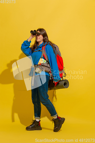 Image of Full length portrait of a cheerful young caucasian tourist girl isolated on yellow background