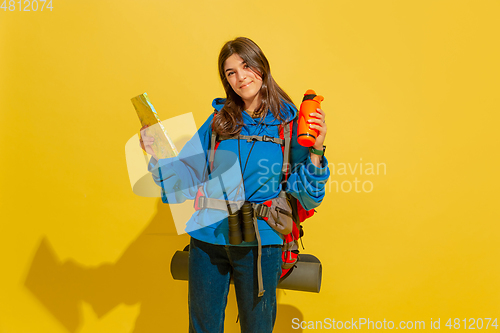 Image of Full length portrait of a cheerful young caucasian tourist girl isolated on yellow background