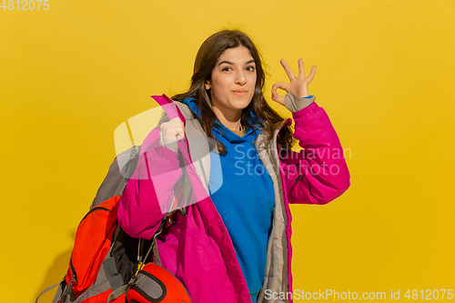 Image of Portrait of a cheerful young caucasian tourist girl isolated on yellow background