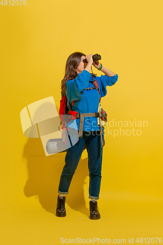 Image of Full length portrait of a cheerful young caucasian tourist girl isolated on yellow background