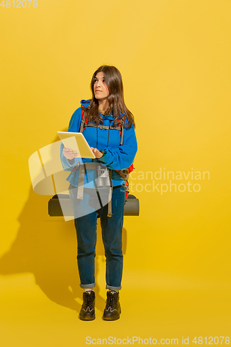 Image of Full length portrait of a cheerful young caucasian tourist girl isolated on yellow background