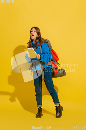 Image of Full length portrait of a cheerful young caucasian tourist girl isolated on yellow background