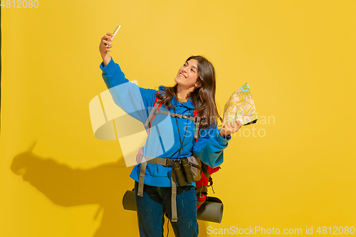 Image of Full length portrait of a cheerful young caucasian tourist girl isolated on yellow background