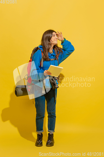 Image of Full length portrait of a cheerful young caucasian tourist girl isolated on yellow background