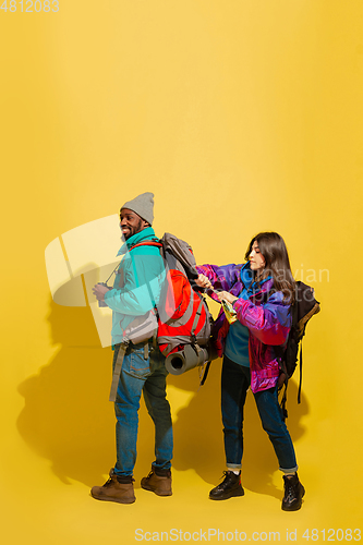 Image of Portrait of a cheerful young tourist couple isolated on yellow background