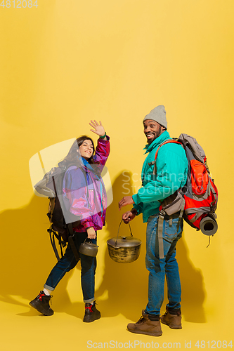 Image of Portrait of a cheerful young tourist couple isolated on yellow background