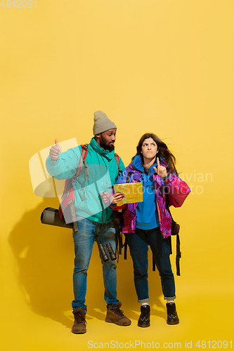 Image of Portrait of a cheerful young tourist couple isolated on yellow background