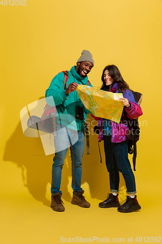 Image of Portrait of a cheerful young tourist couple isolated on yellow background