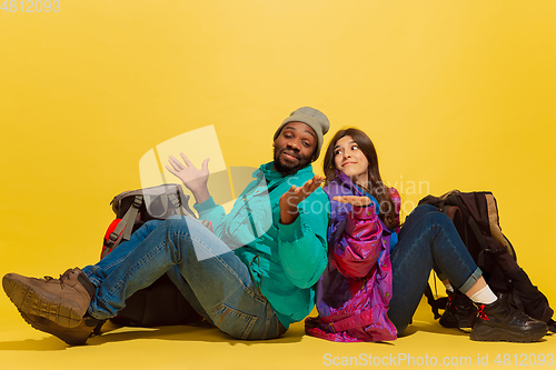 Image of Portrait of a cheerful young tourist couple isolated on yellow background