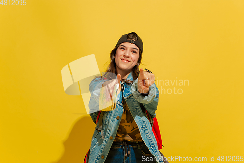 Image of Portrait of a cheerful young caucasian tourist girl isolated on yellow background