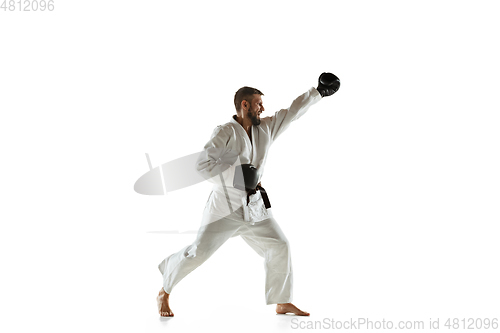 Image of Confident coach in kimono practicing hand-to-hand combat, martial arts