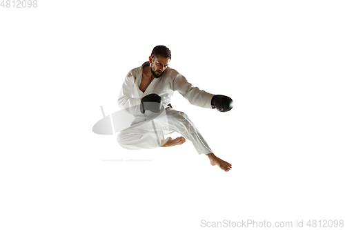 Image of Confident coach in kimono practicing hand-to-hand combat, martial arts