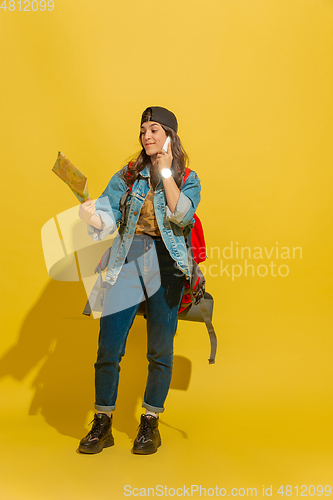 Image of Portrait of a cheerful young caucasian tourist girl isolated on yellow background