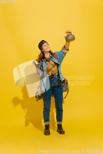 Image of Portrait of a cheerful young caucasian tourist girl isolated on yellow background