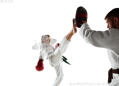 Image of Junior in kimono practicing hand-to-hand combat with coach, martial arts