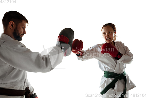 Image of Junior in kimono practicing hand-to-hand combat with coach, martial arts