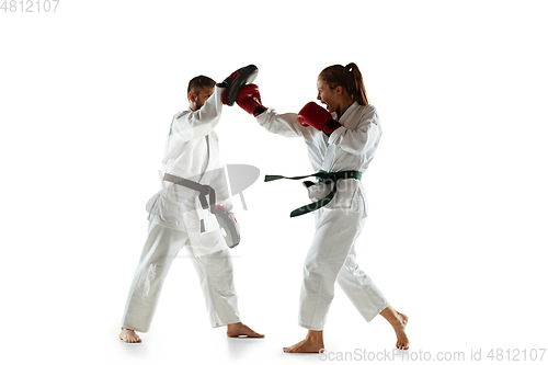 Image of Junior in kimono practicing hand-to-hand combat with coach, martial arts