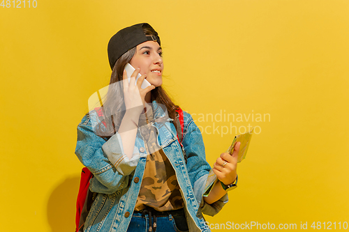 Image of Portrait of a cheerful young caucasian tourist girl isolated on yellow background