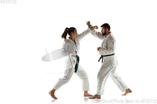 Image of Junior in kimono practicing hand-to-hand combat with coach, martial arts