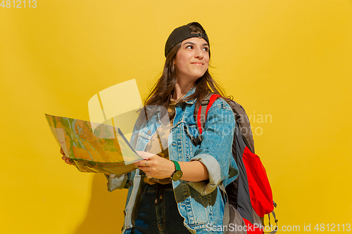 Image of Portrait of a cheerful young caucasian tourist girl isolated on yellow background