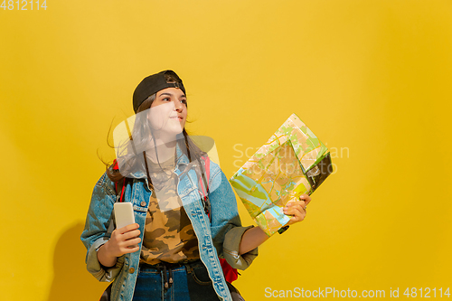 Image of Portrait of a cheerful young caucasian tourist girl isolated on yellow background