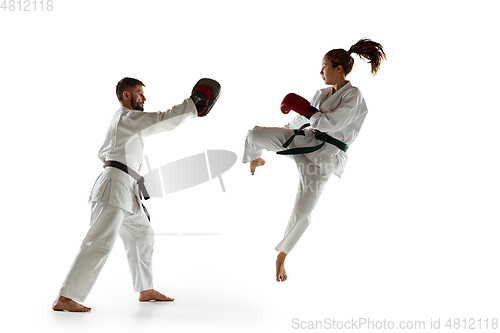 Image of Junior in kimono practicing hand-to-hand combat with coach, martial arts