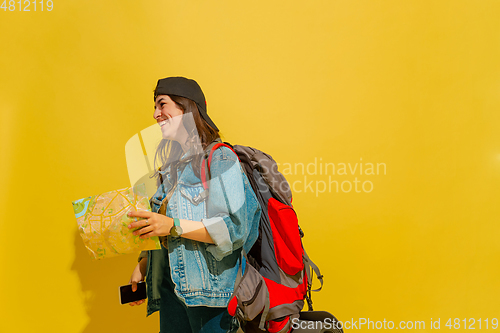 Image of Portrait of a cheerful young caucasian tourist girl isolated on yellow background