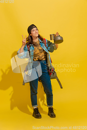 Image of Portrait of a cheerful young caucasian tourist girl isolated on yellow background