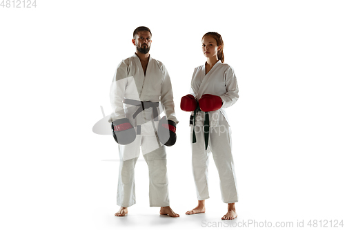 Image of Junior in kimono practicing hand-to-hand combat with coach, martial arts