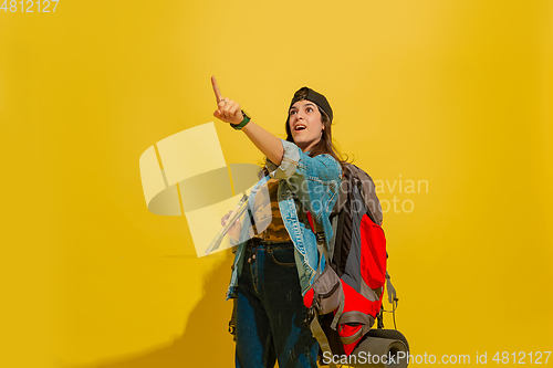 Image of Portrait of a cheerful young caucasian tourist girl isolated on yellow background