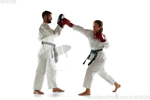 Image of Junior in kimono practicing hand-to-hand combat with coach, martial arts