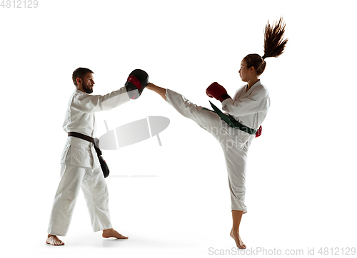 Image of Junior in kimono practicing hand-to-hand combat with coach, martial arts