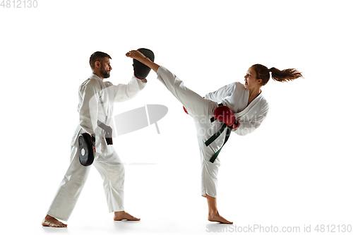 Image of Junior in kimono practicing hand-to-hand combat with coach, martial arts