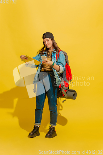 Image of Portrait of a cheerful young caucasian tourist girl isolated on yellow background