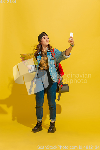 Image of Portrait of a cheerful young caucasian tourist girl isolated on yellow background
