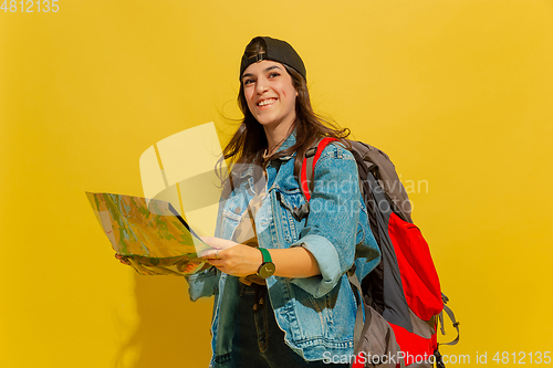 Image of Portrait of a cheerful young caucasian tourist girl isolated on yellow background