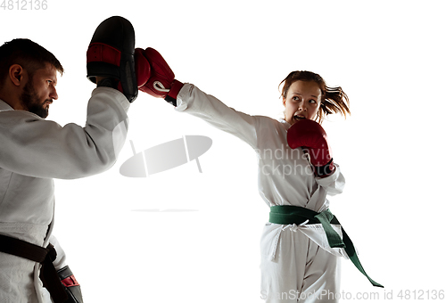 Image of Junior in kimono practicing hand-to-hand combat with coach, martial arts