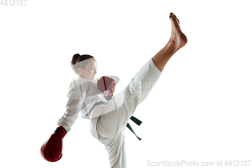 Image of Confident junior in kimono practicing hand-to-hand combat, martial arts