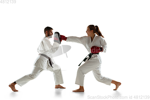 Image of Junior in kimono practicing hand-to-hand combat with coach, martial arts