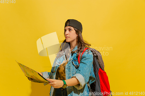 Image of Portrait of a cheerful young caucasian tourist girl isolated on yellow background