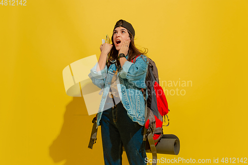 Image of Portrait of a cheerful young caucasian tourist girl isolated on yellow background