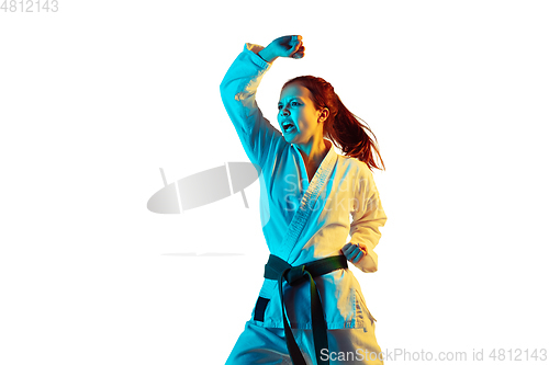 Image of Confident junior in kimono practicing hand-to-hand combat, martial arts