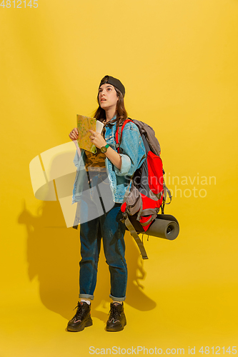 Image of Portrait of a cheerful young caucasian tourist girl isolated on yellow background